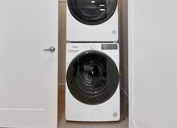 Two white front loading washing machines in a small room.