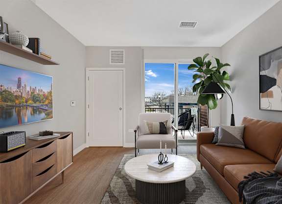 A living room with a brown couch, a coffee table, and a painting on the wall.