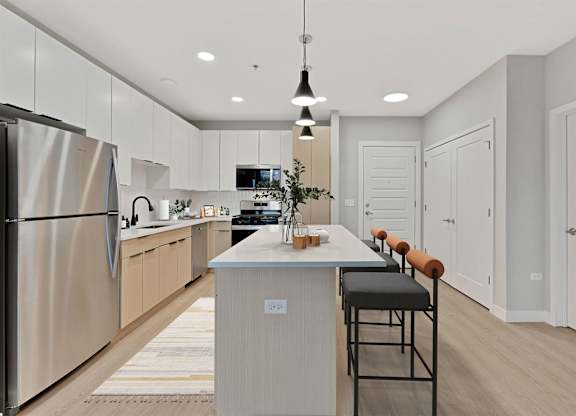 A modern kitchen with a stainless steel refrigerator and a wooden island.