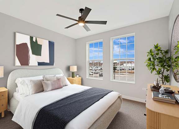 A bedroom with a bed, nightstands, a ceiling fan, and a painting on the wall.