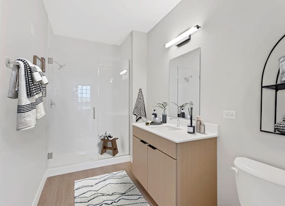 A bathroom with a white tub, sink, and a mirror.