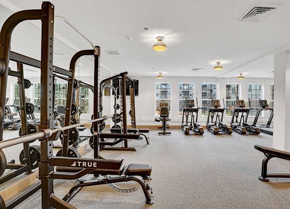 A gym with a variety of equipment including a bench with the word TRUE on it.