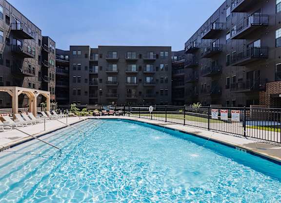 A swimming pool in front of apartment buildings.