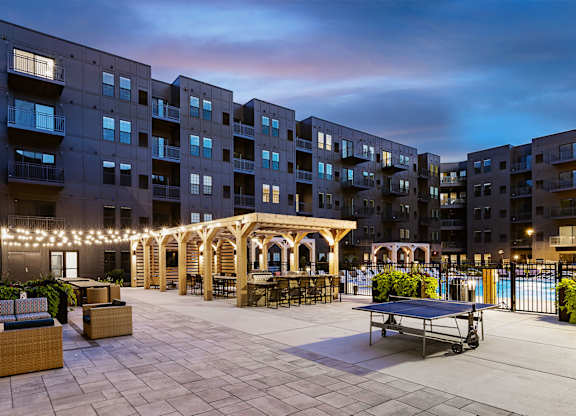 A courtyard with a gazebo, seating, and a pool surrounded by apartment buildings.