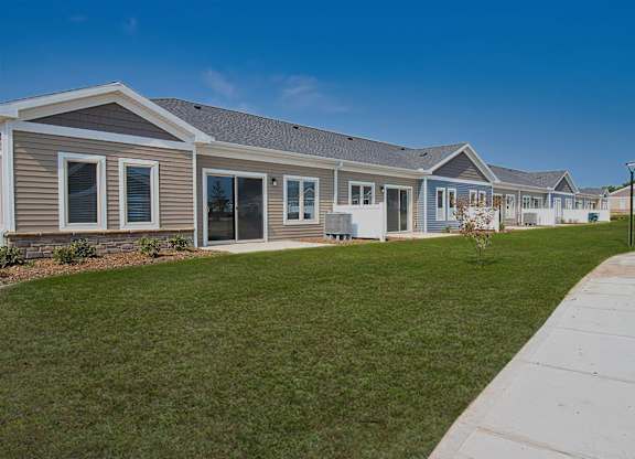 A row of houses with a sidewalk in front.