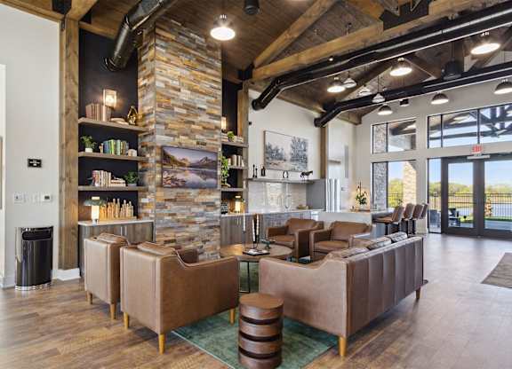 A living room with a stone fireplace and a large sectional sofa.