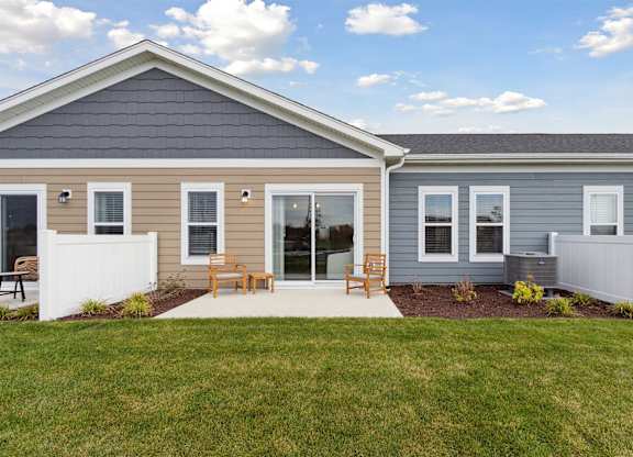 A house with a grey roof and a white fence.