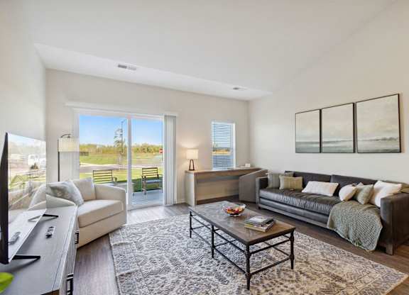 A living room with a couch, a coffee table, and a television.