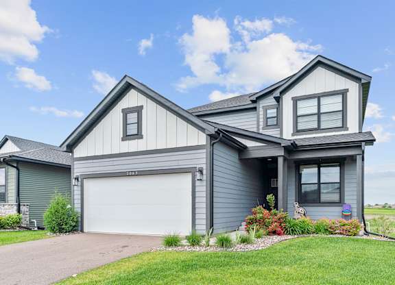 A modern house with a grey exterior and a white garage door.