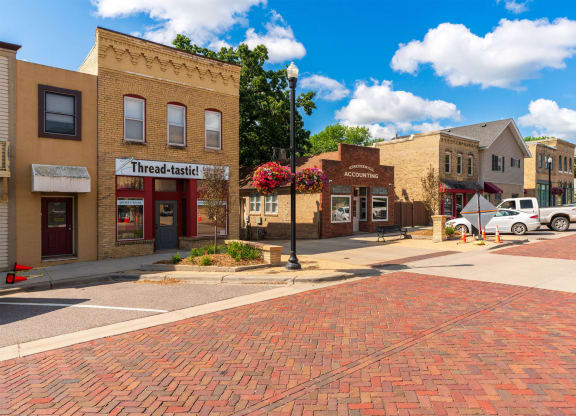 a city street with brick buildings and cars on the corner