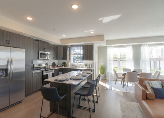 a kitchen and dining room with stainless steel appliances and a table and chairs
