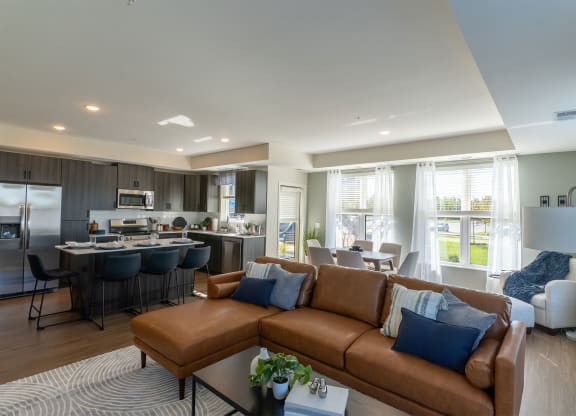 a living room with a couch and a kitchen with a table and chairs