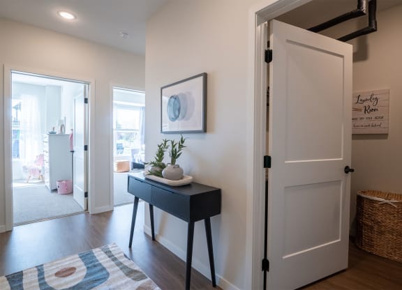 an open door leading into a living room with a black table and a white door