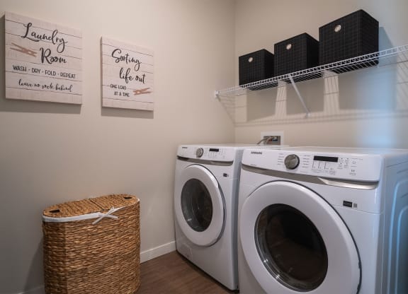 a washer and dryer in a laundry room with a basket next to it