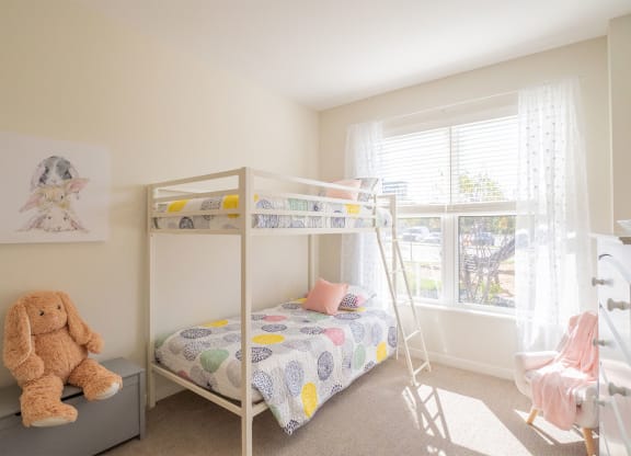 a bedroom with a bunk bed and a teddy bear