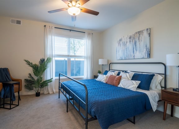 a bedroom with a bed and a ceiling fan and a window
