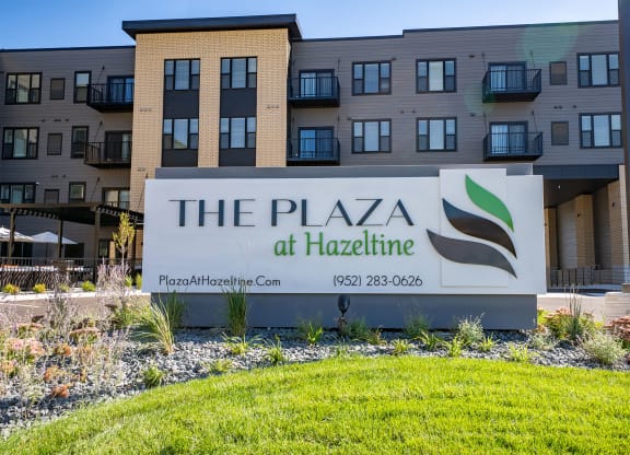 a sign for the plaza at hackettle in front of an apartment building