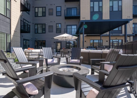 an outdoor patio with chairs and a fire pit