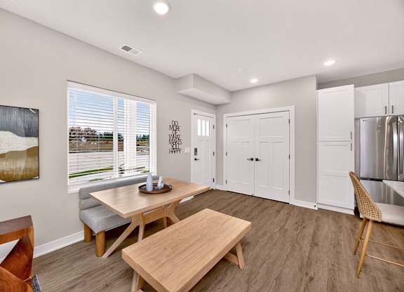 A modern dining room with a wooden table and chairs.