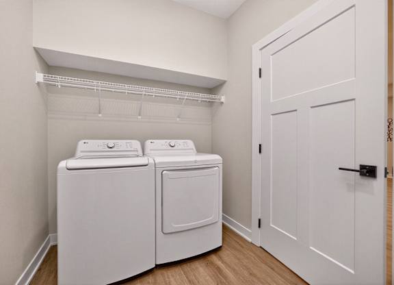 A white laundry room with a washer and dryer.