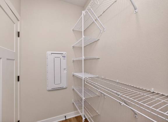 A white metal shelving unit in a room with a white door.