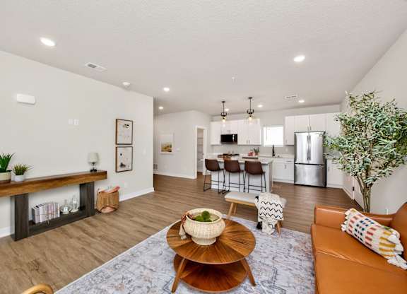 A living room with a brown coffee table and a brown couch.