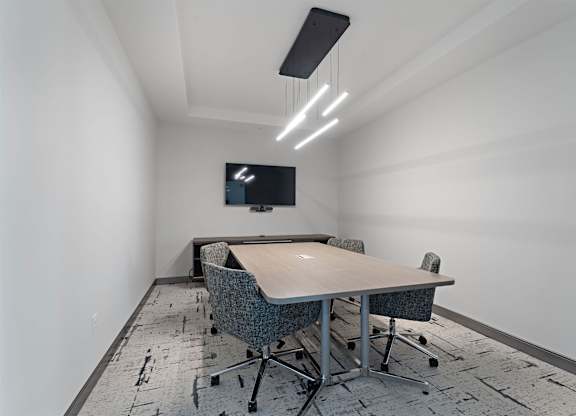 A conference room with a long table and chairs.