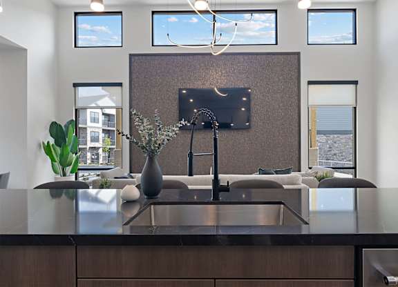 A modern kitchen with a dark brown countertop and a large island.