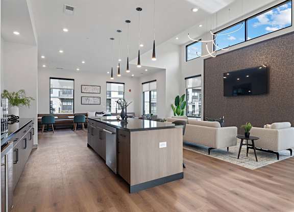 A modern kitchen with a wooden floor and a large island in the middle.