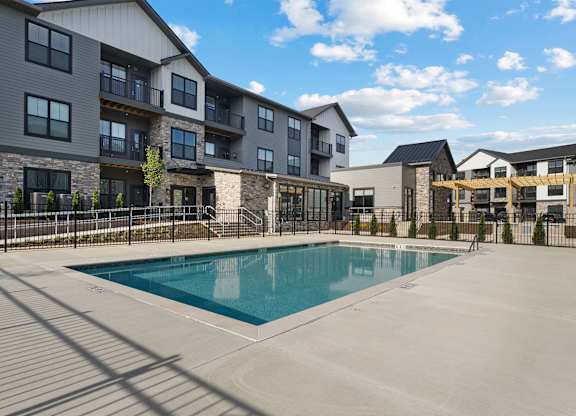 A swimming pool is surrounded by apartment buildings.