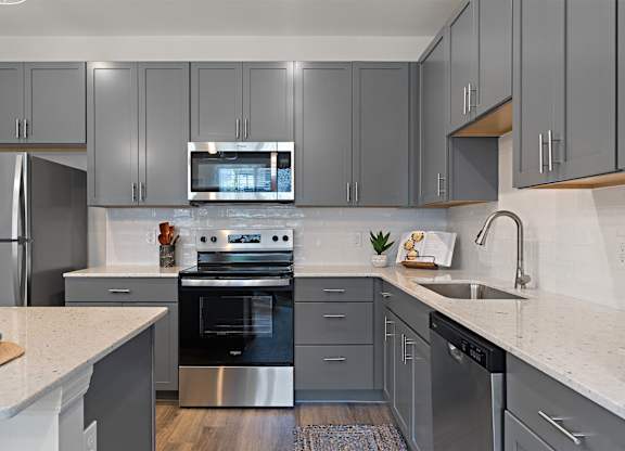 A modern kitchen with a stainless steel oven and microwave.