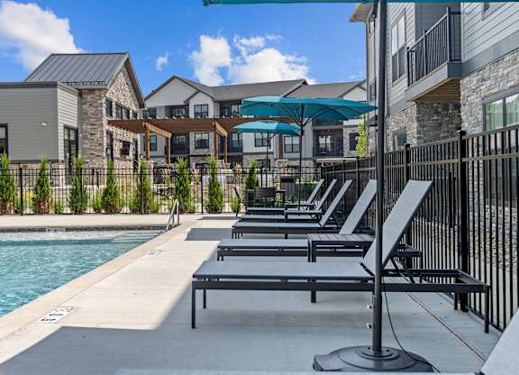 A poolside area with sun loungers and a pool.