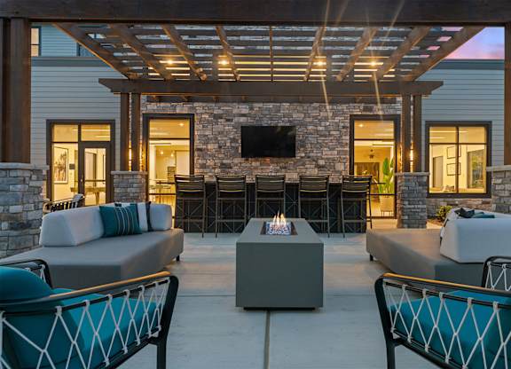 A patio with a stone fireplace and seating area.
