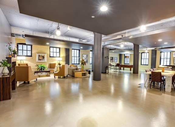 A spacious room with a high ceiling and a mix of modern and vintage furniture.