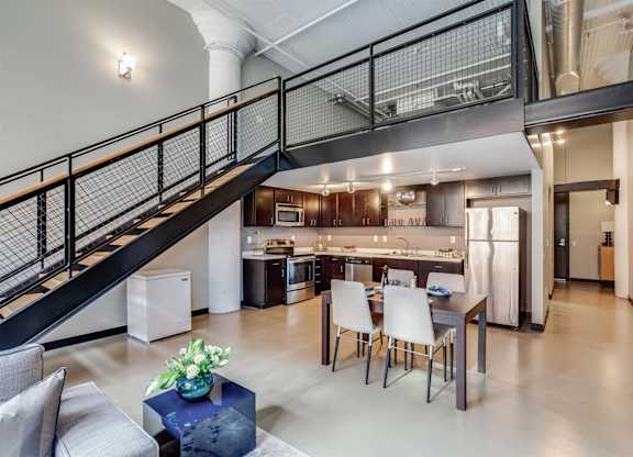 A modern open concept living space with a kitchen in the background.