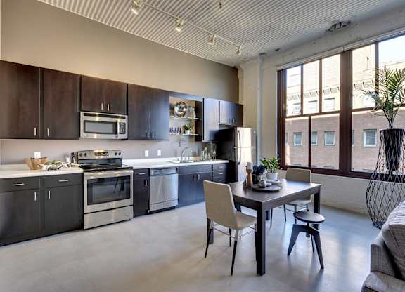 A modern kitchen with a dining table and chairs.