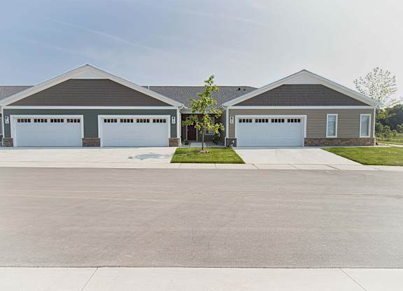 A large, two-story building with a garage door on each side.