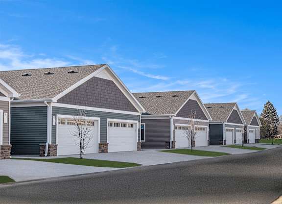 A row of houses with garages and driveways.