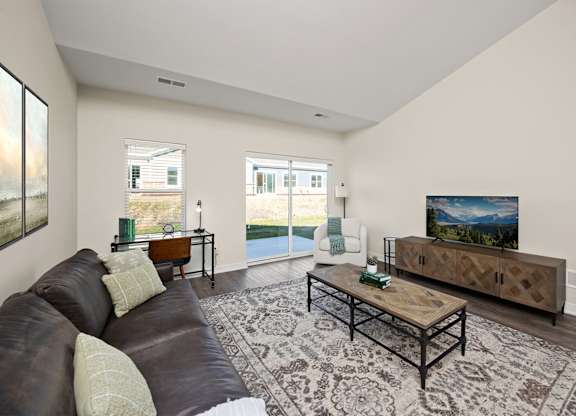 A living room with a brown leather couch and a wooden coffee table.