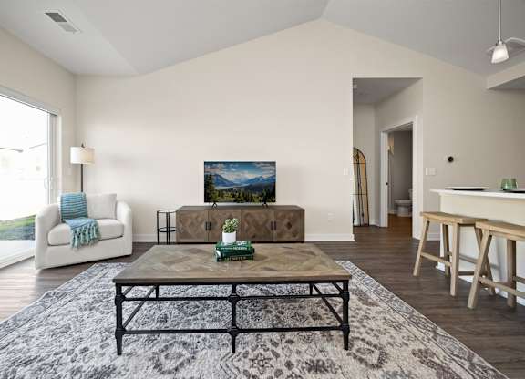 A living room with a couch, coffee table, and a painting on the wall.