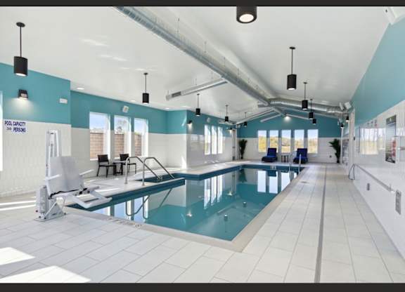 A large indoor swimming pool with a diving board and lane markers.