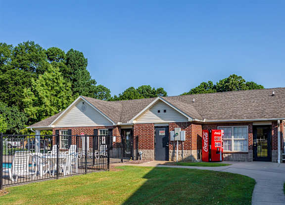 A building with a red Coca-Cola vending machine in front.