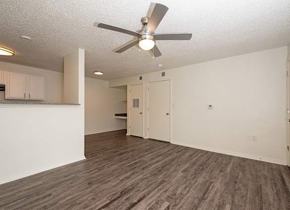 A room with a ceiling fan and wooden flooring.