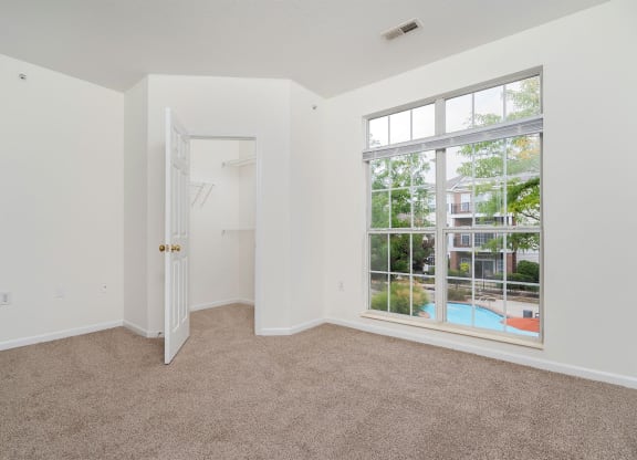 a bedroom with a large window and a door to a pool