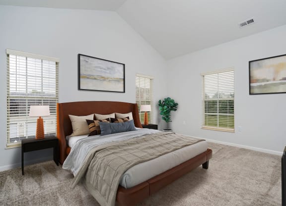 a bedroom with a bed and two windows
