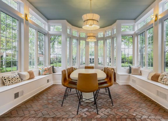 a dining room with a table and chairs and windows