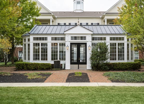 the front of a white house with a black door