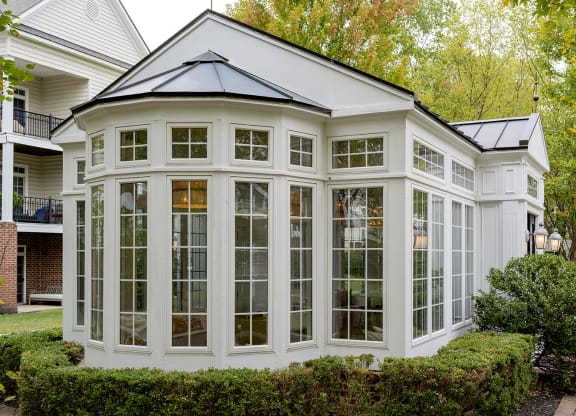 a conservatory with large windows on the side of a house