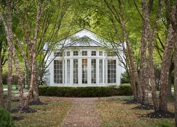 a white house in the woods with trees