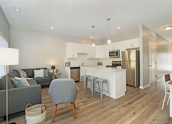 A modern kitchen with a grey chair in the middle of the room.